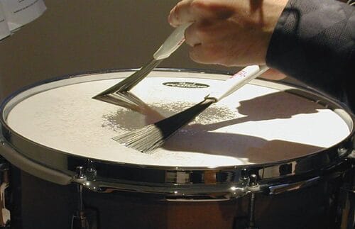 Quel style de musique est fortement associé aux balais qu’on utilise pour taper sur des percussions ? 