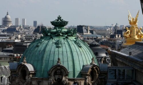 En quel matériau est réalisé le toit de ce bâtiment de Paris au premier plan ? 