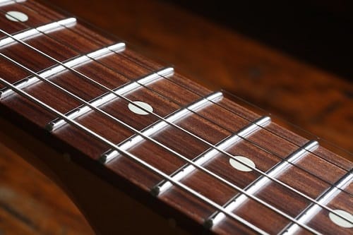 Comment s’appellent les bandes métalliques horizontales qui se trouvent sur le manche d'une guitare ? 