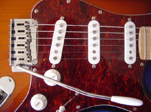 Quel est le nom de la tige présente sur certaines guitares électriques ? 