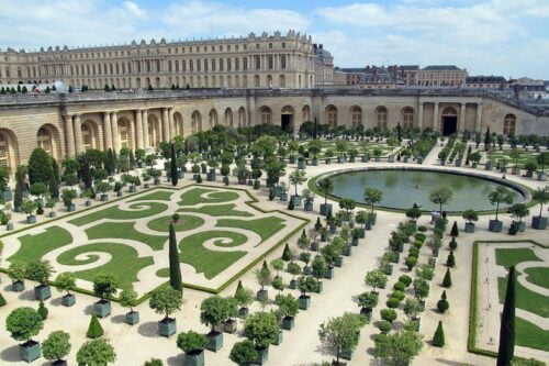 Qui est à l'origine des aménagements et jardins du château de Versailles ? 